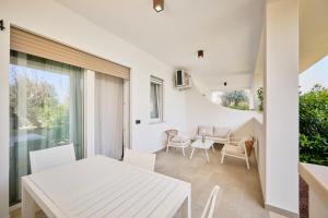 a kitchen and dining room with a white table and chairs at Pilone del Monaco - Pool & Free Parking in Vieste