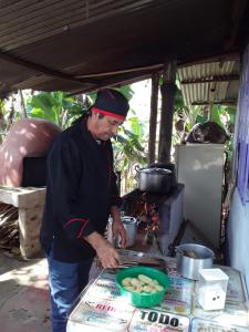 a man preparing food in front of a stove at Casa La Aurora Posada in Restrepo