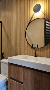 a bathroom with a sink and a mirror on the wall at Studio moderno no centro de vinhedo in Vinhedo +15 photos
