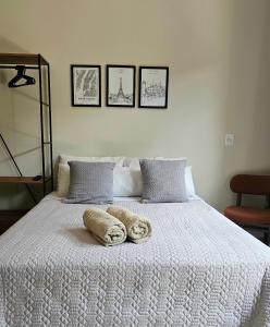 a white bed with two towels on top of it at Studio moderno no centro de vinhedo in Vinhedo