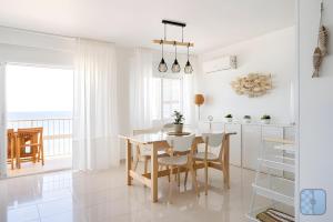a kitchen and dining room with a table and chairs at El Acuario - Primera línea y todas las ventanas dan al mar in Cullera