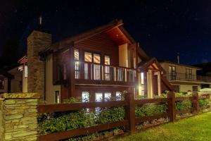 a house with a fence in front of it at night at Mountain View Chalet in Wanaka