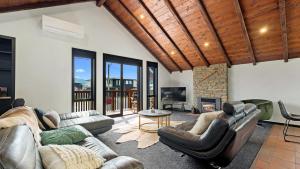 a living room with two couches and a fireplace at Mountain View Chalet in Wanaka
