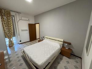 a white bedroom with a bed and a door at Apartment house in the center in Oggiono