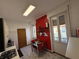 a kitchen with red walls and a small table in it at Apartment house in the center in Oggiono