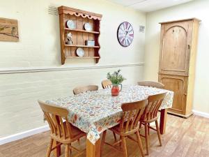a dining room table with chairs and a clock on the wall at Brook House 2 - Uk31043 in Bassenthwaite