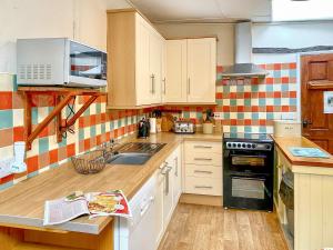 a kitchen with a sink and a stove top oven at Brook House 2 - Uk31043 in Bassenthwaite +26 photos