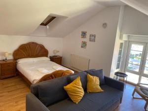 a bedroom with a bed and a blue couch at R2R - Tríplex Rinconín con piscina - 158A in Gijón +35 photos
