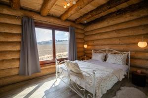 a bedroom with a bed in a log cabin at Zrub Kriváň Chalet with Mountain View in Závažná Poruba
