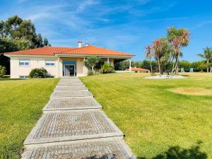 a house with a pathway leading to a yard at Villa Vieira in Alvarães