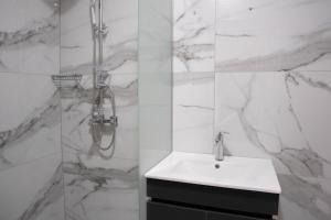 a white bathroom with a sink and a shower at Hotel Joana in Prizren +14 photos