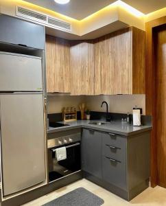 a kitchen with stainless steel appliances and wooden cabinets at Tokyo in Maarif