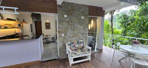 a room with a kitchen and a balcony with a table at Estúdio Beija-flor Itaipava in Araras Petropolis