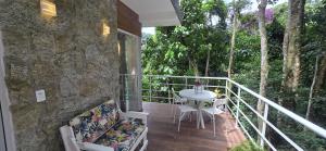 a balcony of a house with a table and chairs at Estúdio Beija-flor Itaipava in Araras Petropolis