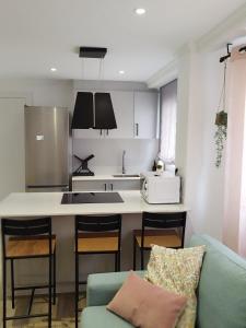 a kitchen with a blue couch and a kitchen counter at Pretodomar2 in A Coruña