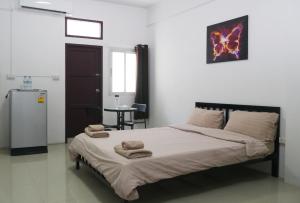 a bedroom with a bed with towels on it at Baan Mai Guest House in Bangkok