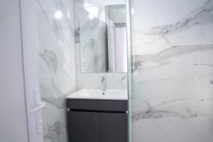 a white bathroom with a sink and a mirror at Hotel Joana in Prizren