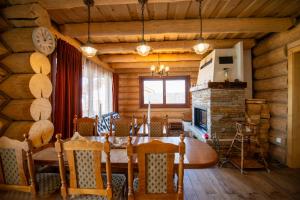 a dining room with a table and a fireplace at Zrub Kriváň Chalet with Mountain View in Závažná Poruba