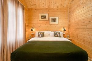 a bedroom with a large bed in a wooden wall at Kahani Cottages Palampur in Paror