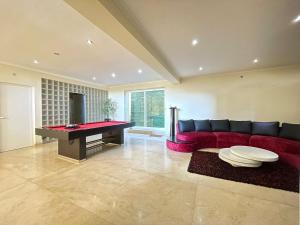 a living room with a red couch and a pool table at Villa Vieira in Alvarães