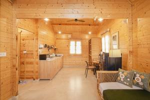 a log cabin with a kitchen and a living room at Kahani Cottages Palampur in Paror
