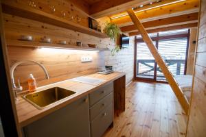 a kitchen with a sink and a wooden wall at Zrub Kriváň Chalet with Mountain View in Závažná Poruba +107 photos
