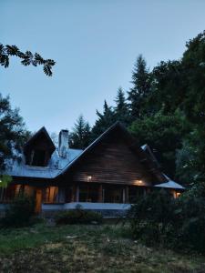 a wooden house with lights on the side of it at Bosque Hostel in Villa Traful