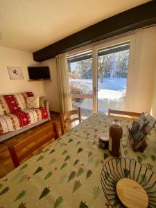 a bedroom with a table and a bed and a window at Appartement Saint chaffrey in Saint-Chaffrey
