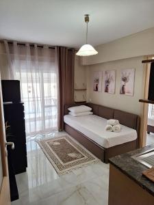 a small room with a bed and a kitchen at Sammys apartments in Nea Potidaea