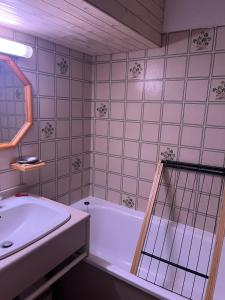 a bathroom with a white tub and a sink at Appartement Saint chaffrey in Saint-Chaffrey
