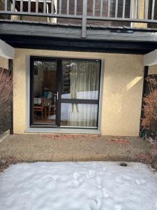 a house with sliding glass doors and snow in front of it at Appartement Saint chaffrey in Saint-Chaffrey