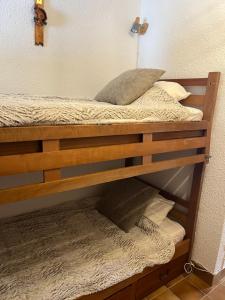 a wooden bunk bed with pillows on it at Appartement Saint chaffrey in Saint-Chaffrey