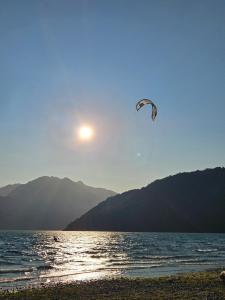 a kite flying in the sky over a body of water at Camping Delta del Azul in Lago Puelo