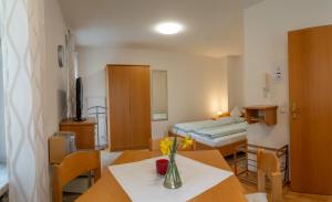 a room with a bed and a table with flowers on it at Appartementhof Stadler in Pocking