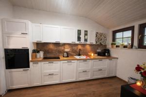 a kitchen with white cabinets and a black appliance at Villa Christina in Kamp-Bornhofen