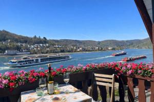 a table with a bottle of wine and some flowers at Villa Christina in Kamp-Bornhofen