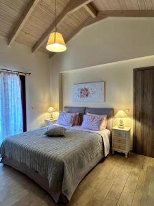 a bedroom with a bed with two night stands and two lamps at Villa Cottage Kantrillies in Kefallonia +39 photos