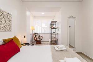 a white bedroom with a red bed and a mirror at Doormans House city center by Homeful Homes in Lisbon +16 photos