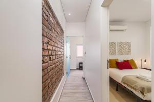 a bedroom with a brick wall next to a bed at Doormans House city center by Homeful Homes in Lisbon