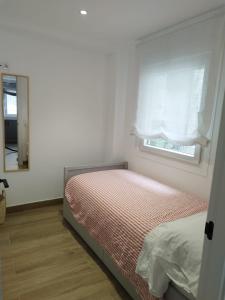 a small bedroom with a bed and a window at Pretodomar2 in A Coruña