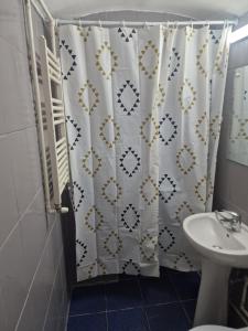 a bathroom with a shower curtain and a sink at Eroilor Downtown Studio in Cluj-Napoca
