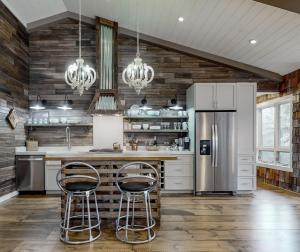 eine Küche mit Kühlschrank und zwei Barhockern in der Unterkunft The Fifth - Stunning Luxury Rental in Downtown Highlands NC in Highlands