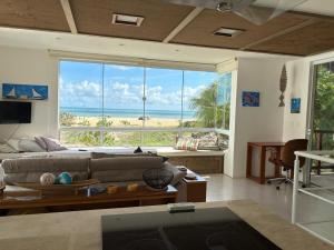 a living room with a couch and a large window at Beach Front Exclusive Villa with Pool in São Miguel do Gostoso