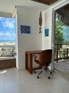 a desk and a chair in a room with a window at Beach Front Exclusive Villa with Pool in São Miguel do Gostoso +70 photos