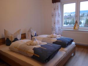 two beds with stuffed animals on them in a bedroom at Bergidylle in Kurort Oberwiesenthal