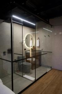 a glass room with a bathroom with a toilet and a mirror at Casa Leon Hotel R Top in Rionegro