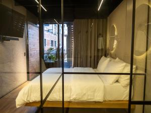 a bed with white sheets and pillows in a room at Casa Leon Hotel R Top in Rionegro +11 photos