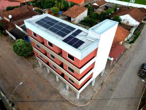a building with solar panels on the roof at Hotel e Pousada França in Manhã