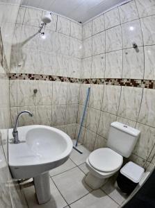 a bathroom with a white toilet and a sink at Hotel e Pousada França in Manhã