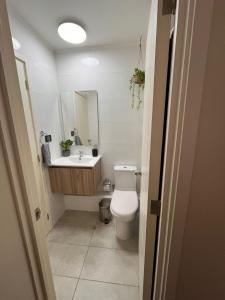 a bathroom with a toilet and a sink and a mirror at Lindo Brisas in Talcahuano +4 photos